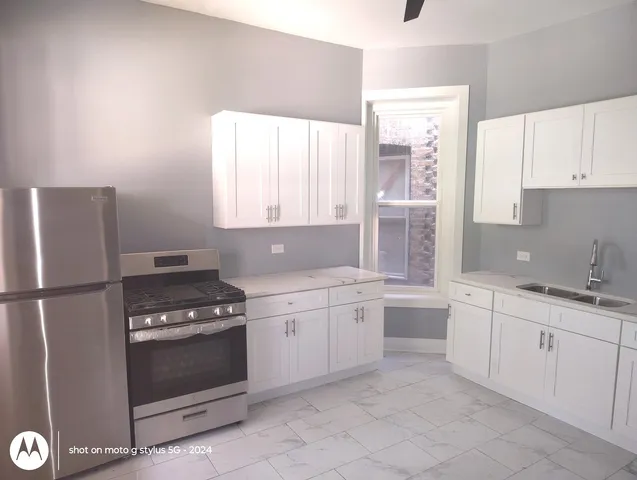 a kitchen with white cabinets and white appliances