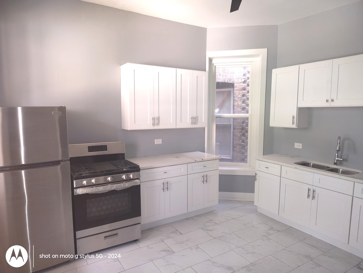 1661 South Homan Avenue, Unit 1 Chicago, IL 60623 - Photo 3 of 11 a kitchen with white cabinets and white appliances