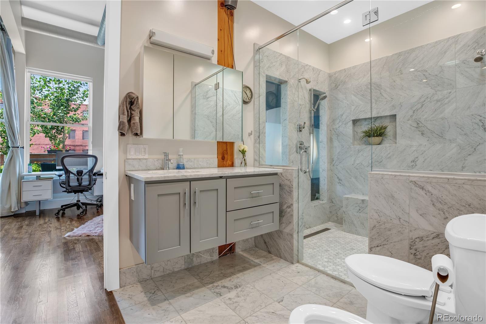 1501 Wazee Street, Unit 4B Denver, CO 80202 - Photo 19 of 40 a bathroom with a sink a toilet a mirror and shower
