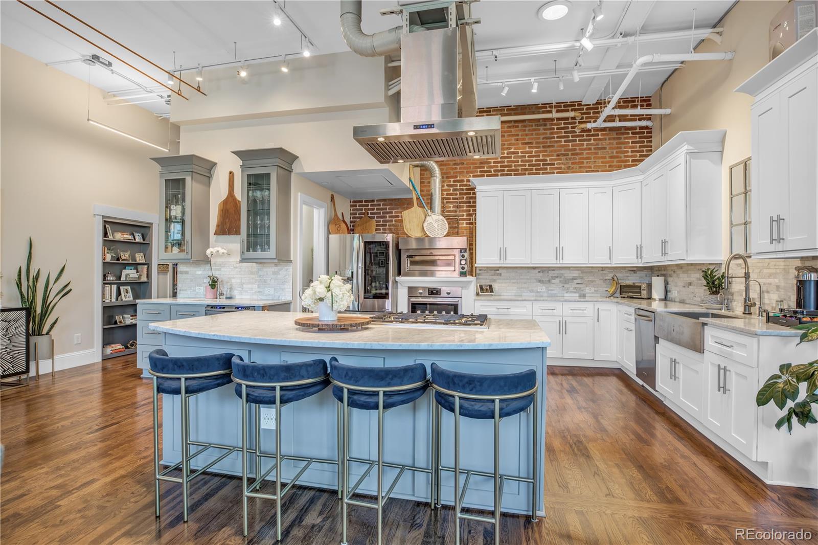 1501 Wazee Street, Unit 4B Denver, CO 80202 - Photo 8 of 40 a kitchen with stainless steel appliances granite countertop a kitchen island a stove a table and chairs in it