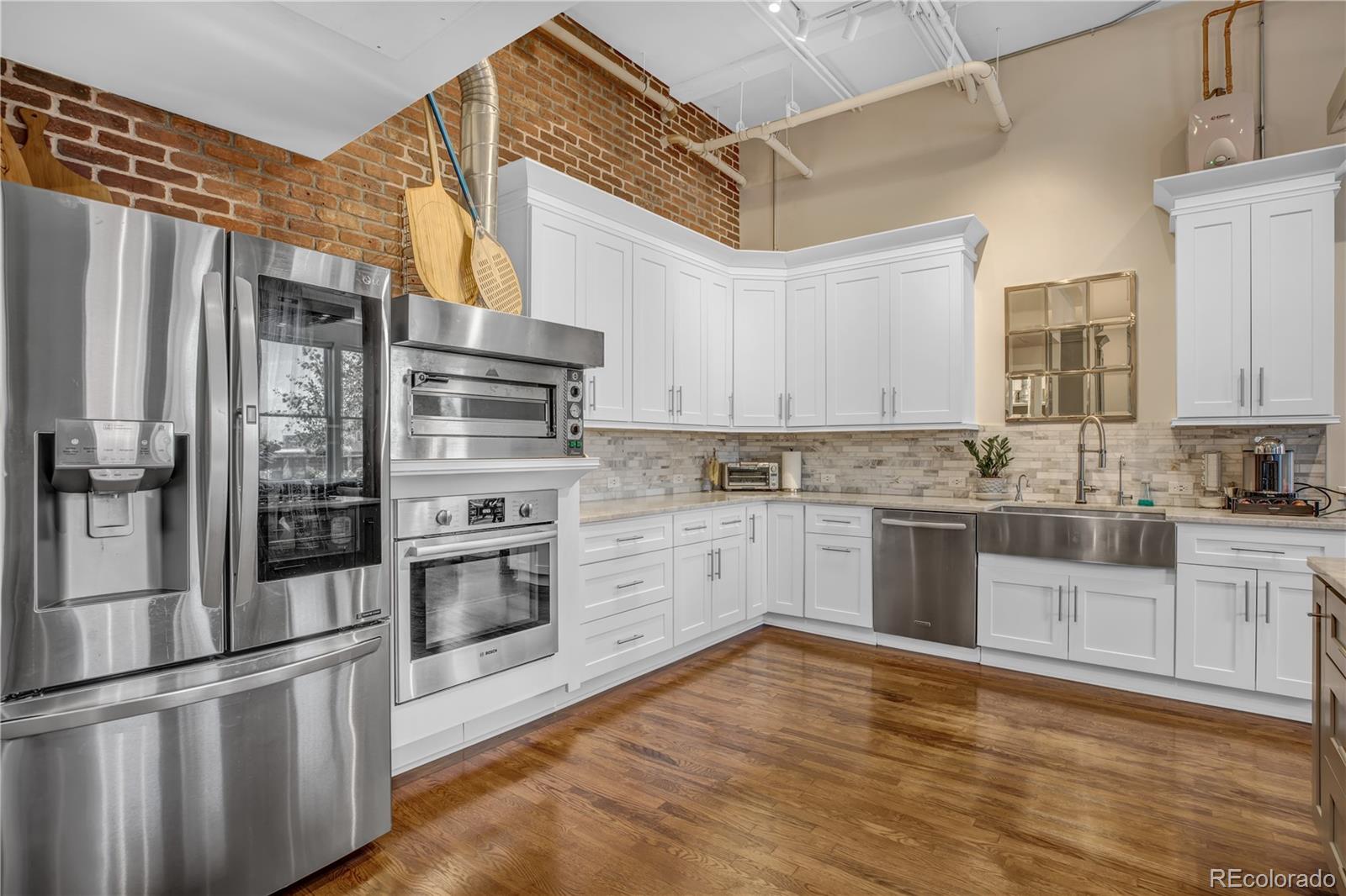 1501 Wazee Street, Unit 4B Denver, CO 80202 - Photo 9 of 40 a kitchen with stainless steel appliances and white cabinets