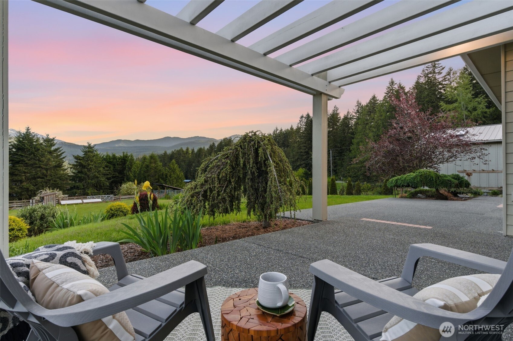 2263 Lost Mountain Road Sequim, WA 98382 - Photo 13 of 40 a backyard of a house with yard table and chairs
