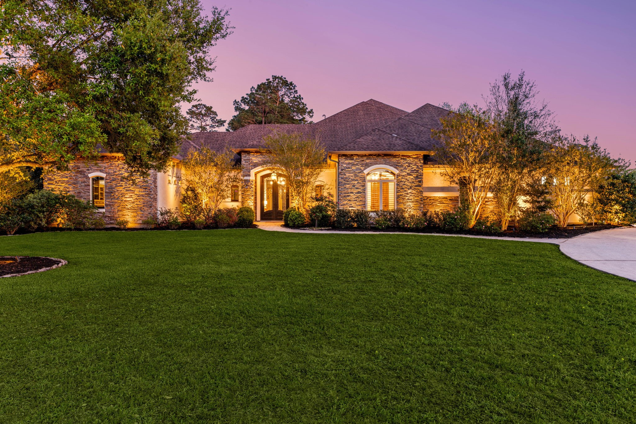 Beautiful elevation with lush landscaping and outdoor lighting
