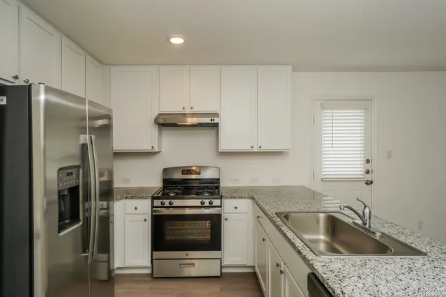 a kitchen with a refrigerator sink and stove