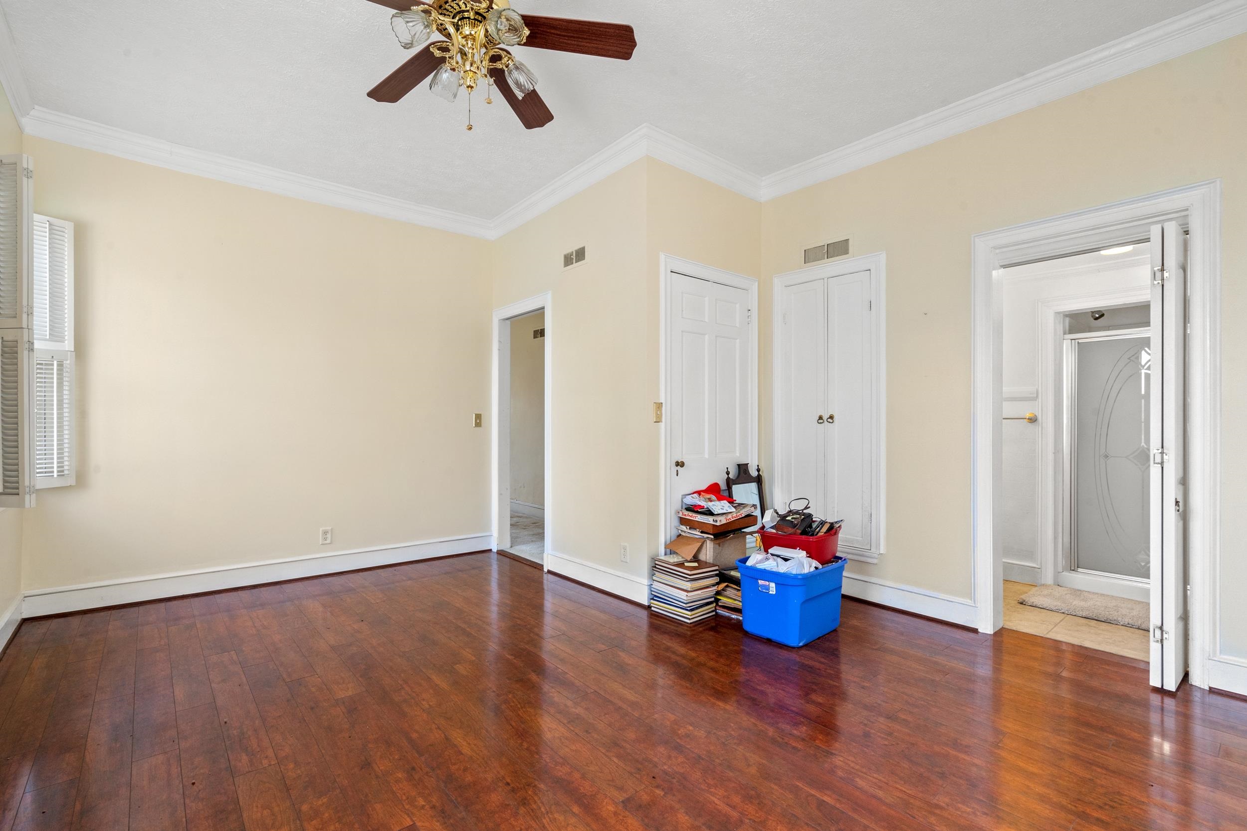 426 North Park Street Mullins, SC 29574 - Photo 15 of 39 Unfurnished bedroom with dark wood-style floors, ornamental molding, a ceiling fan, and ensuite bath