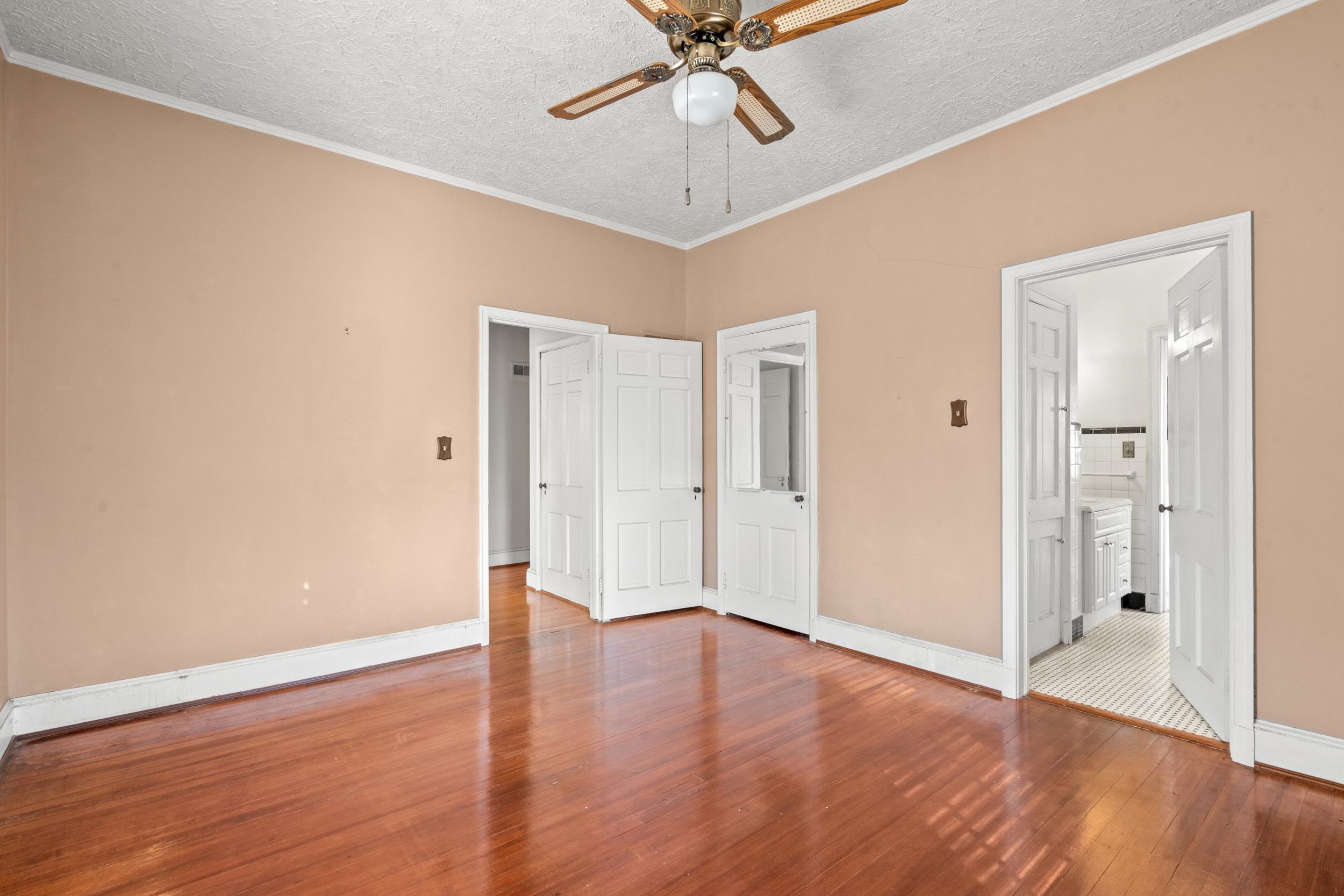 426 North Park Street Mullins, SC 29574 - Photo 17 of 39 Unfurnished bedroom with a textured ceiling, crown molding, hardwood / wood-style floors, ceiling fan, and connected bathroom