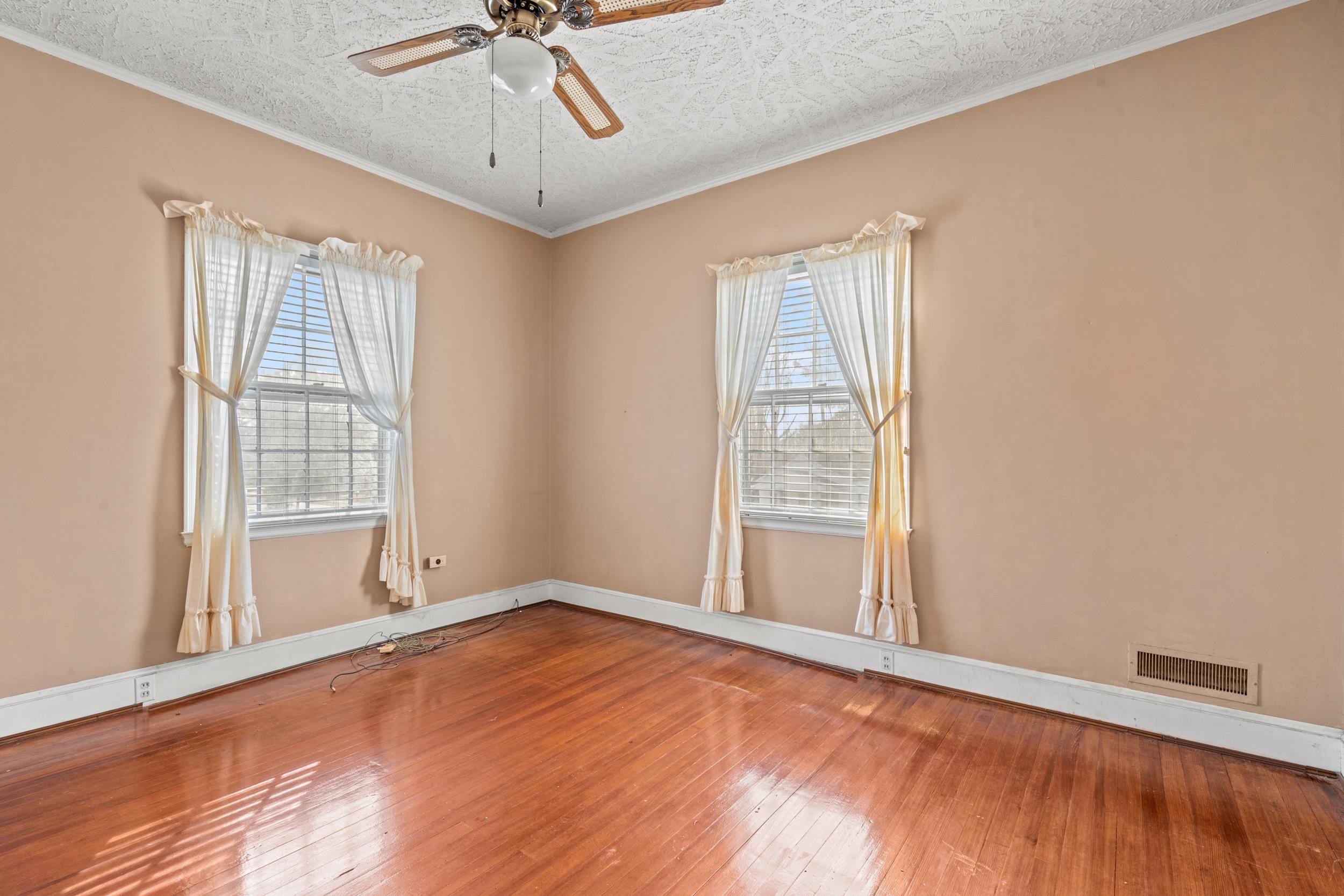 426 North Park Street Mullins, SC 29574 - Photo 18 of 39 Spare room featuring wood-type flooring, a ceiling fan, crown molding, and a textured ceiling