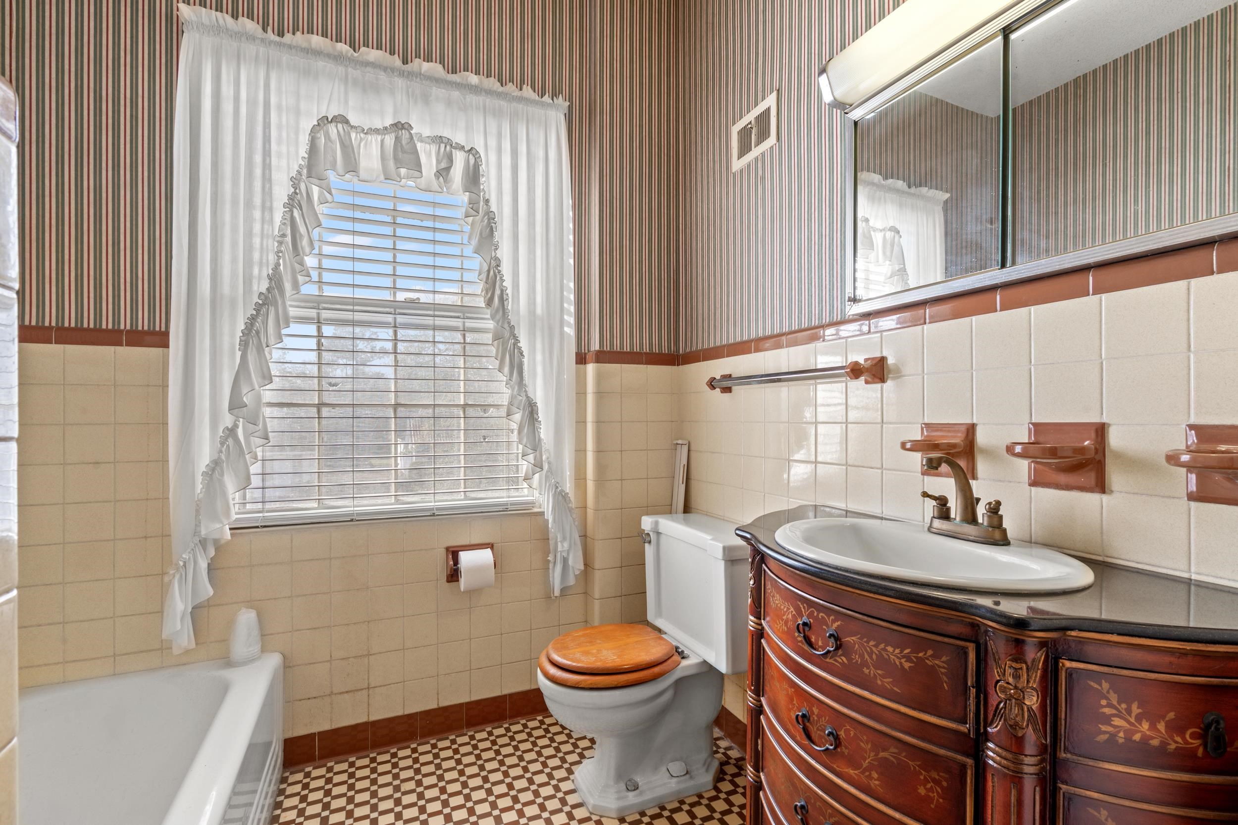 426 North Park Street Mullins, SC 29574 - Photo 23 of 39 Full bathroom with wallpapered walls, tile walls, vanity, a tub to relax in, and wainscoting