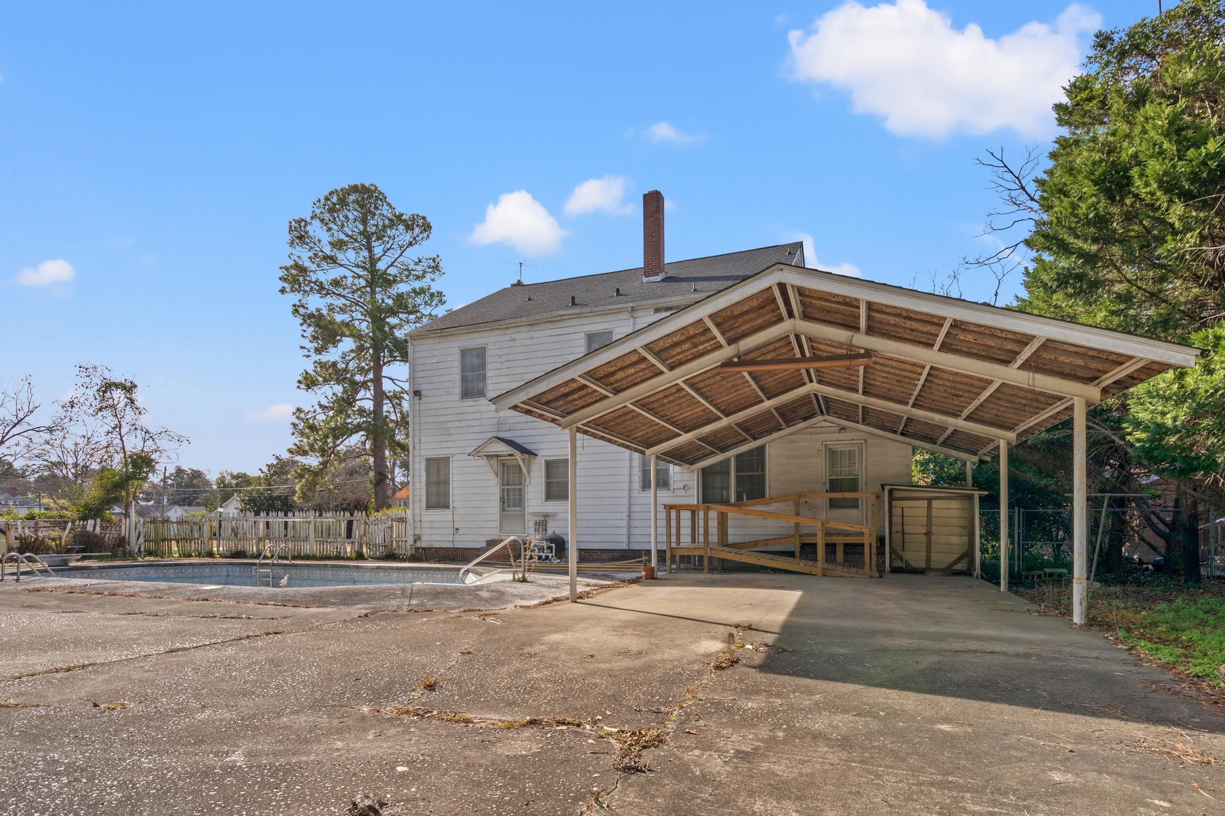 426 North Park Street Mullins, SC 29574 - Photo 34 of 39 Rear view of property with driveway, a detached carport, and a chimney