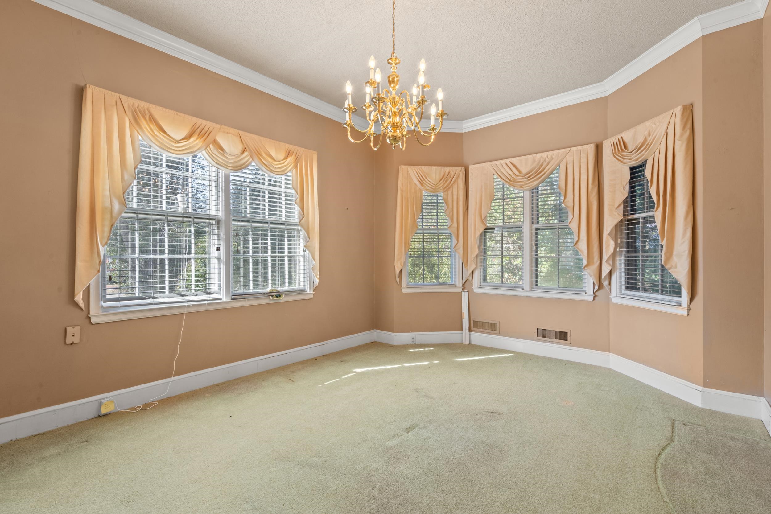 426 North Park Street Mullins, SC 29574 - Photo 6 of 39 Empty room featuring a chandelier, ornamental molding, and carpet floors