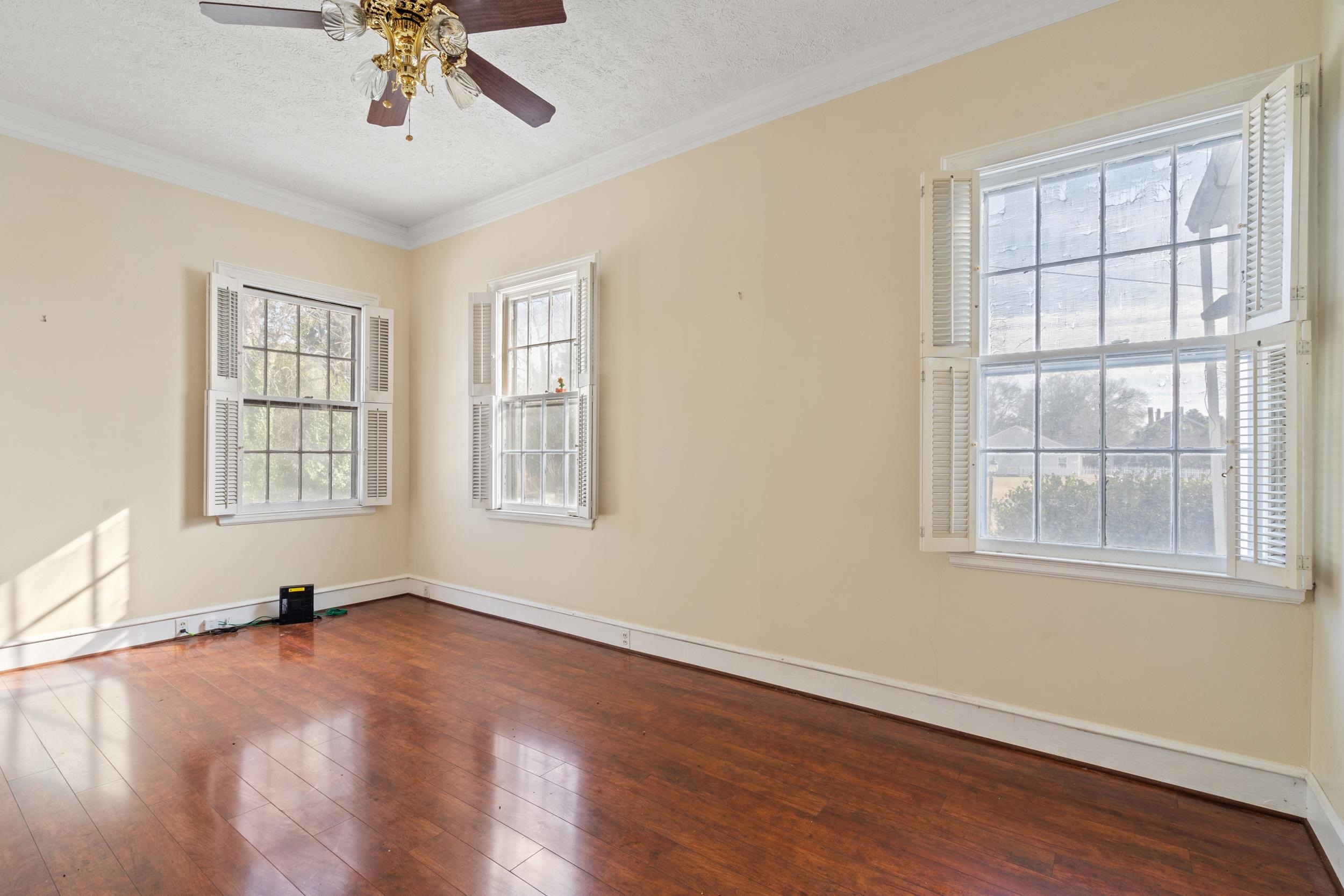 426 North Park Street Mullins, SC 29574 - Photo 8 of 39 Spare room featuring crown molding, dark wood-style floors, a textured ceiling, and a ceiling fan