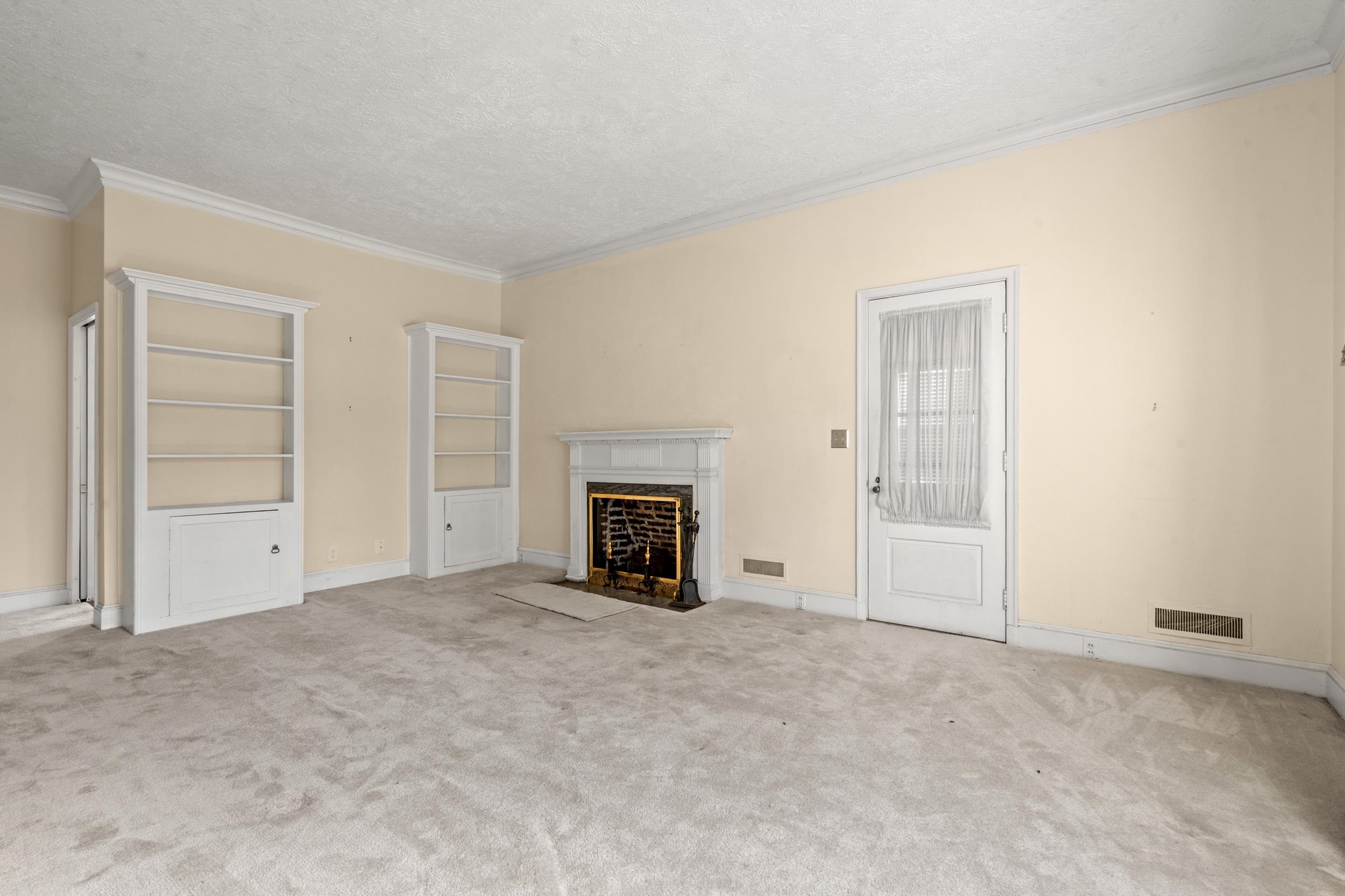 426 North Park Street Mullins, SC 29574 - Photo 10 of 39 Unfurnished living room featuring a high end fireplace, carpet, a textured ceiling, and ornamental molding