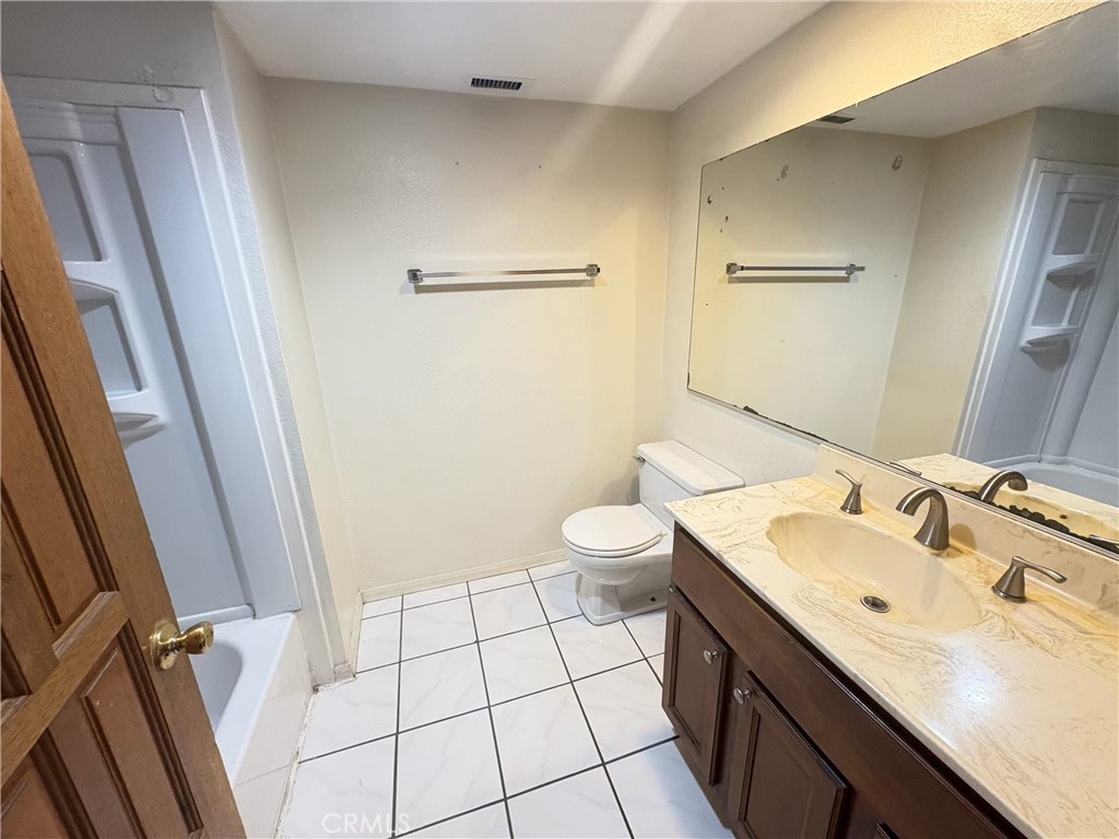 9727 Fremont Avenue Montclair, CA 91763 - Photo 7 of 10 a bathroom with a sink a toilet and a mirror
