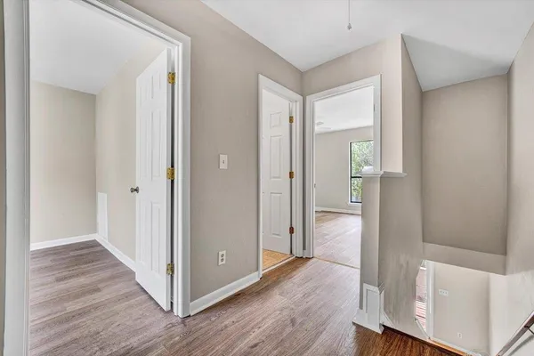 an empty room with wooden floor and window