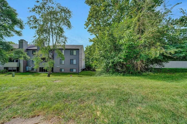 a view of a white house with a large window and a yard