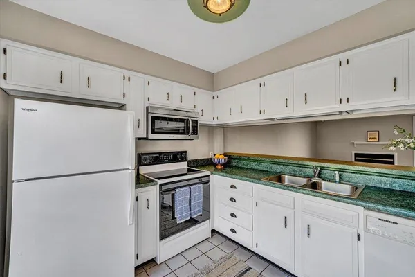 a kitchen with granite countertop white cabinets and stainless steel appliances