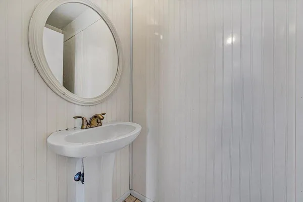 a view of an empty room with kitchen and window