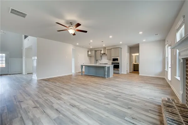 a view of a kitchen and a kitchen with a ceiling fan wooden floor and a ceiling fan