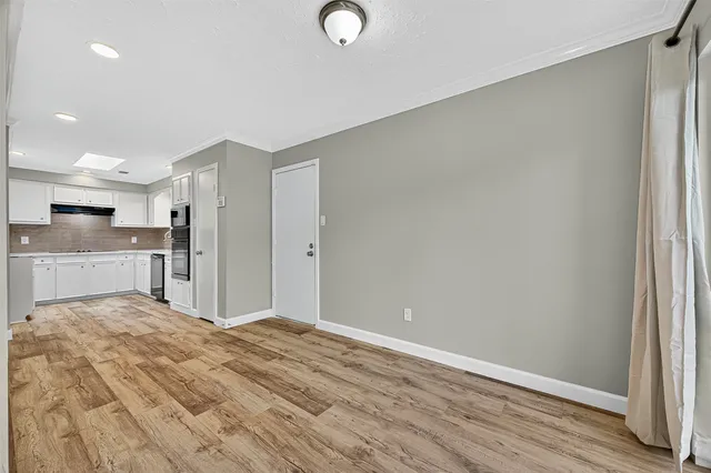 a view of a kitchen with wooden floor and windows