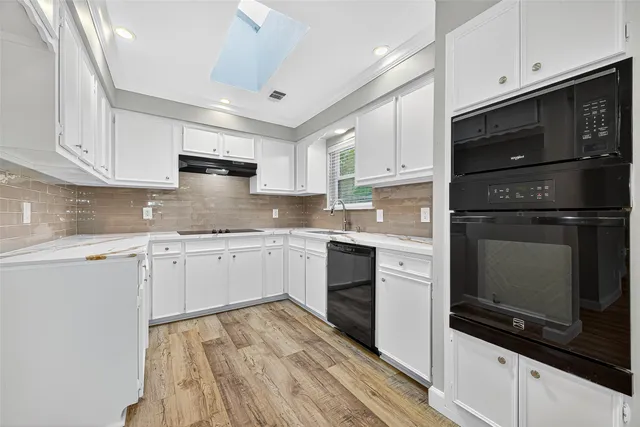 a kitchen with granite countertop white cabinets and appliances