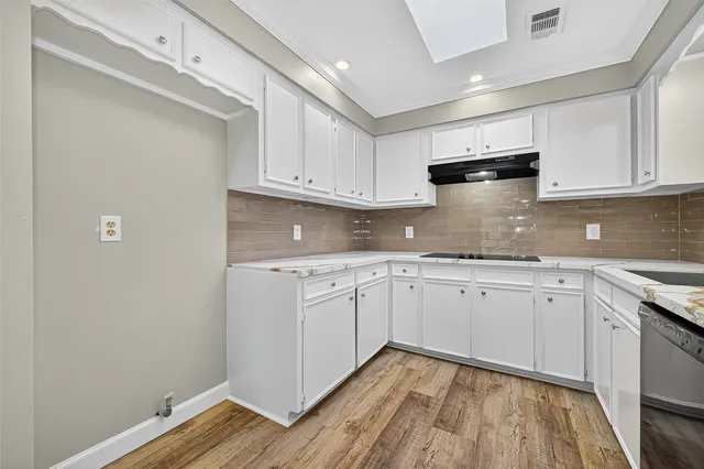 a kitchen with granite countertop white cabinets and white appliances