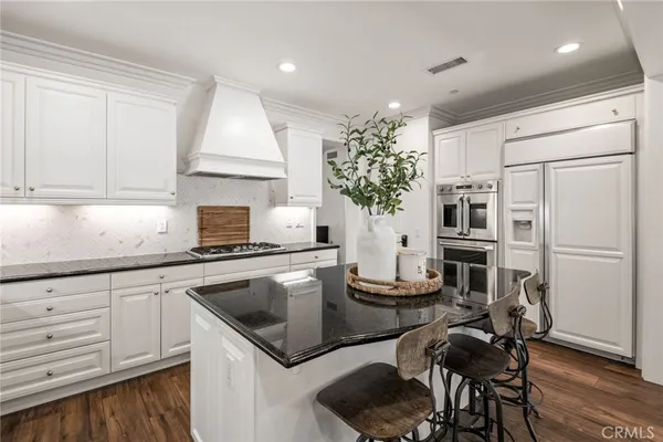 a kitchen with a table chairs stove and wooden floor
