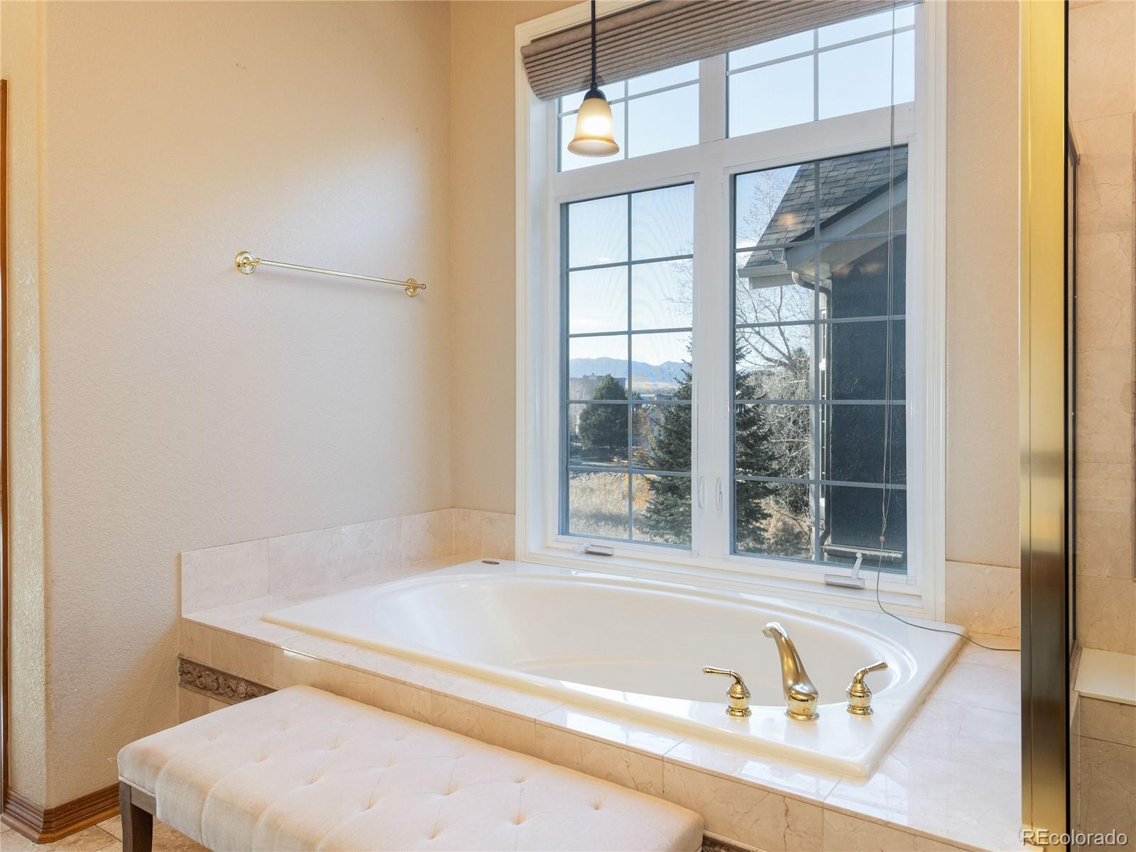 4940 West 107th Loop Westminster, CO 80031 - Photo 18 of 44 a bathroom with a tub and a window