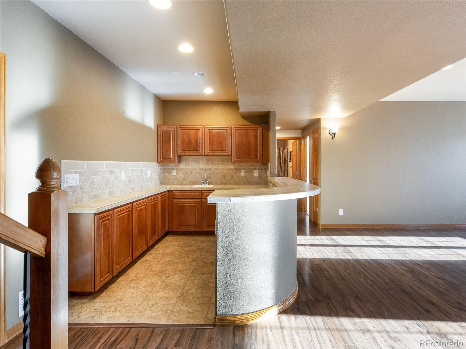 4940 West 107th Loop Westminster, CO 80031 - Photo 28 of 44 a kitchen with kitchen island granite countertop a sink and a stove top oven