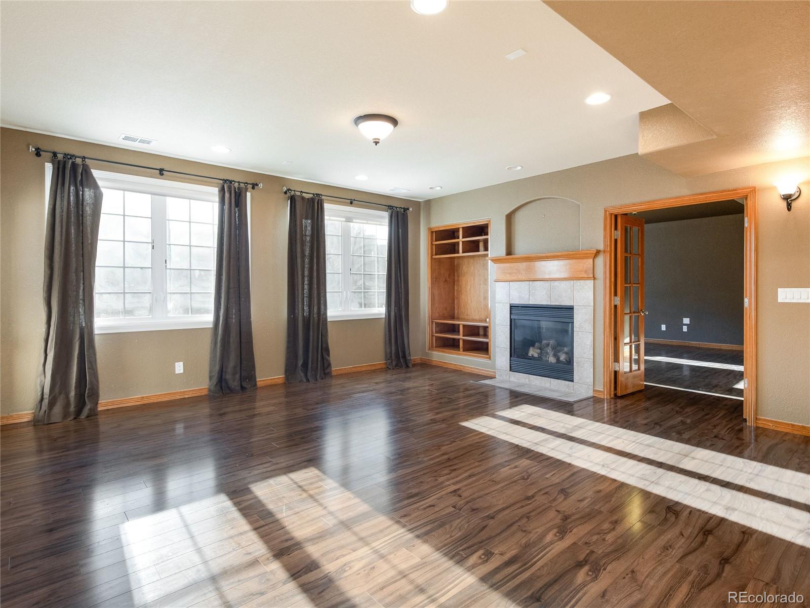 4940 West 107th Loop Westminster, CO 80031 - Photo 30 of 44 a view of an empty room with wooden floor fireplace and a window