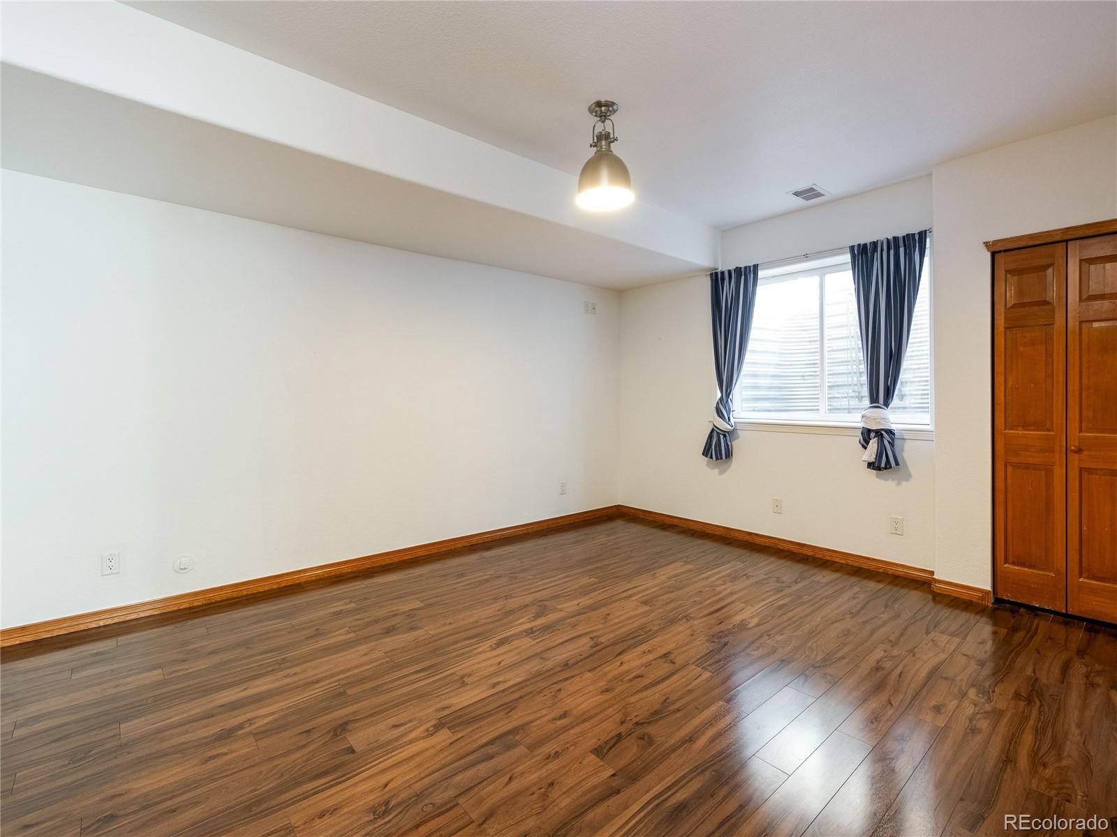 4940 West 107th Loop Westminster, CO 80031 - Photo 33 of 44 an empty room with wooden floor and windows