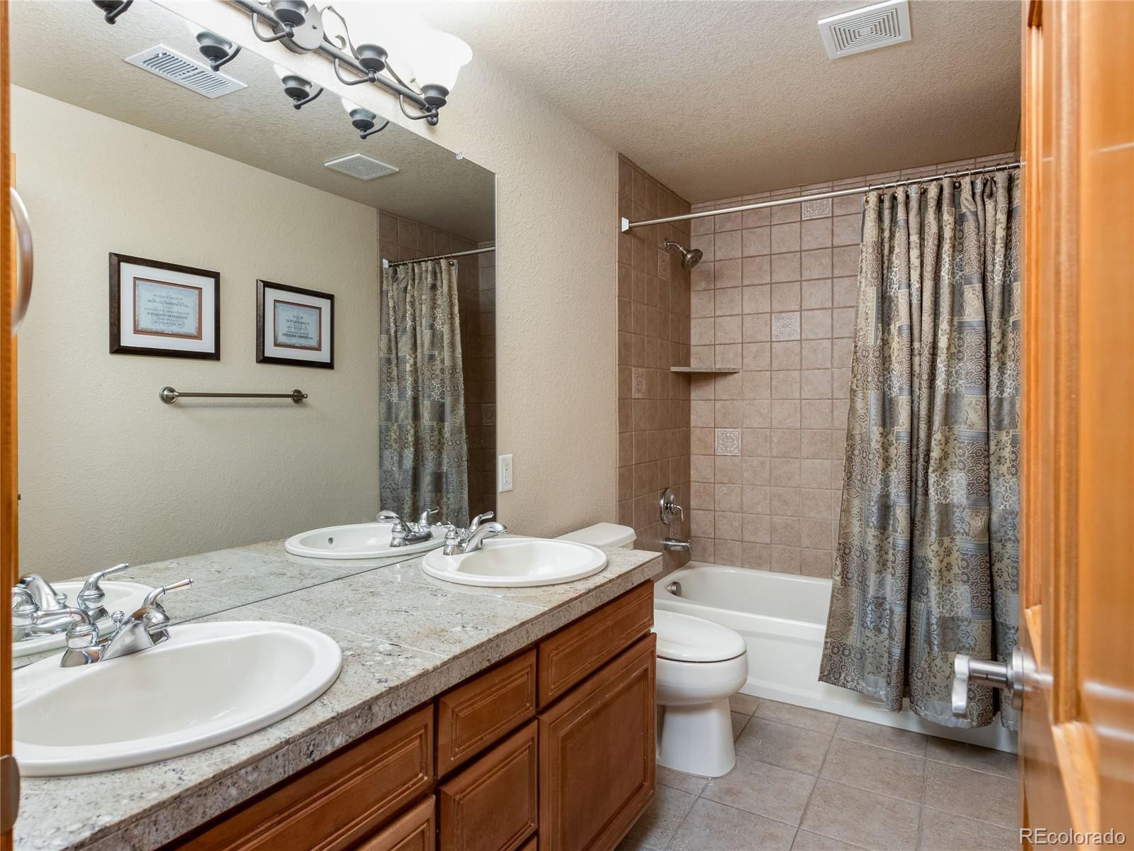 4940 West 107th Loop Westminster, CO 80031 - Photo 34 of 44 a bathroom with a granite countertop sink a toilet and shower