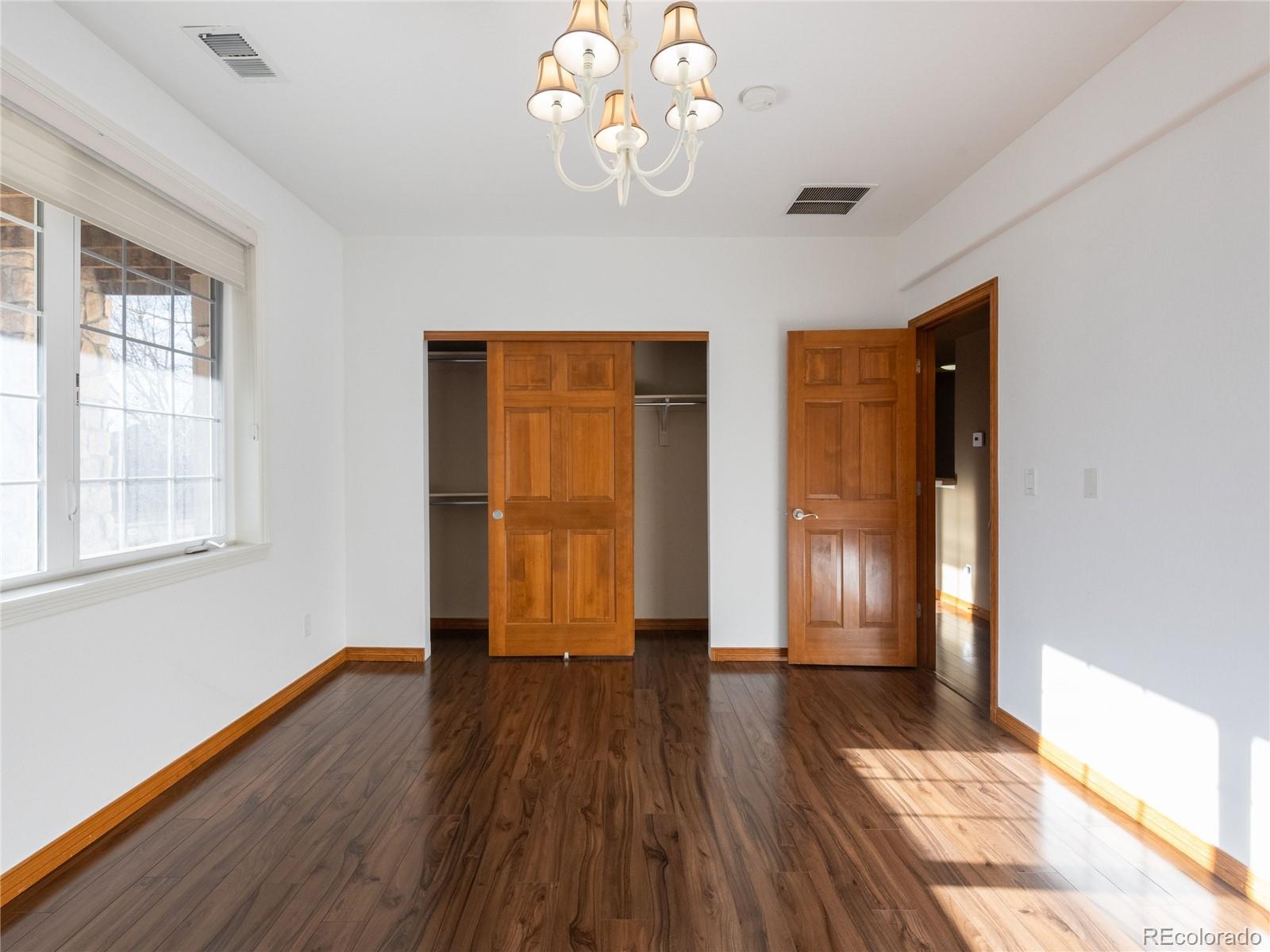 4940 West 107th Loop Westminster, CO 80031 - Photo 36 of 44 a view of an empty room with wooden floor and a window