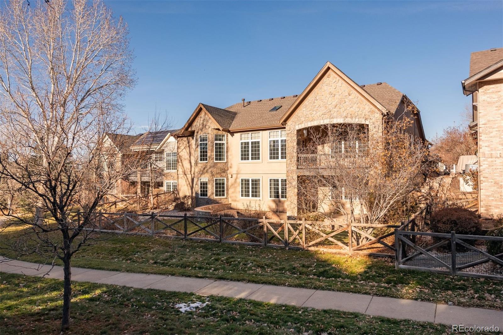 4940 West 107th Loop Westminster, CO 80031 - Photo 42 of 44 a view of a white house next to a yard with large trees