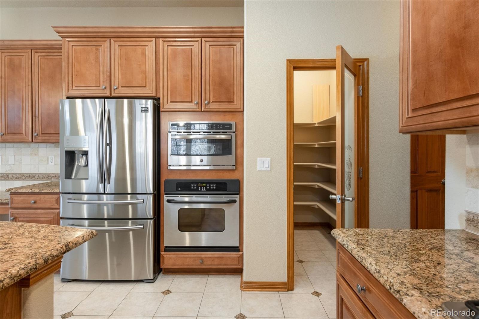 4940 West 107th Loop Westminster, CO 80031 - Photo 7 of 44 a kitchen with granite countertop stainless steel appliances and wooden cabinets
