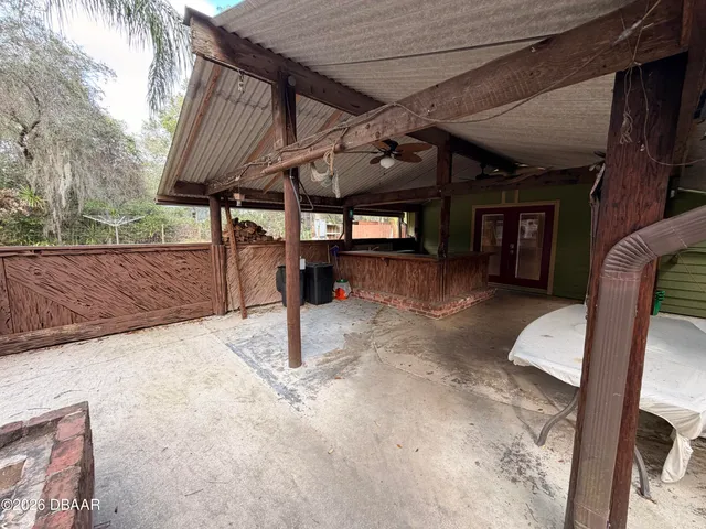 a backyard of a house with barbeque oven and outdoor seating
