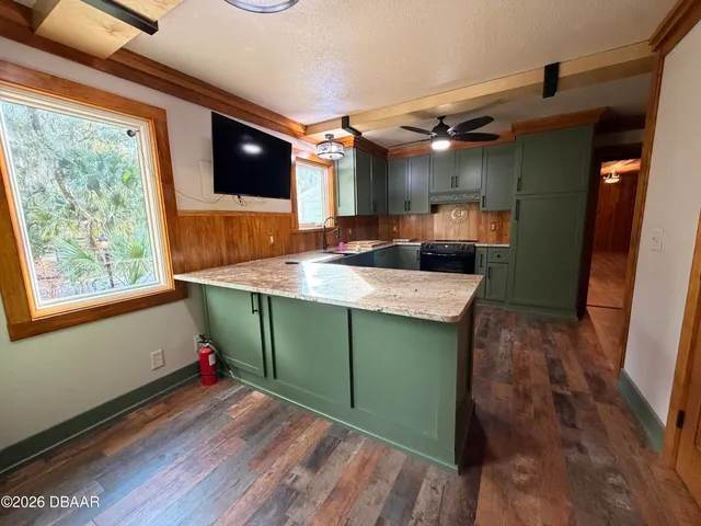 a kitchen with stainless steel appliances granite countertop a refrigerator a sink and a stove