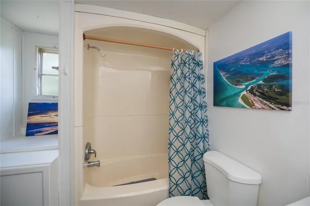 a bedroom with a bed and painting on the wall