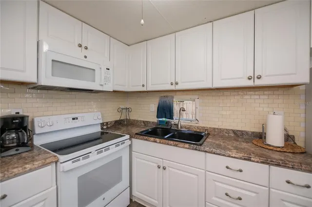 a kitchen with granite countertop white cabinets and a stove