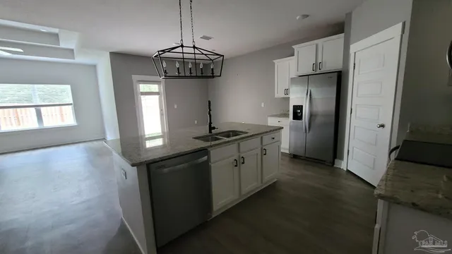 a kitchen with stainless steel appliances a sink a refrigerator a stove a microwave and cabinets