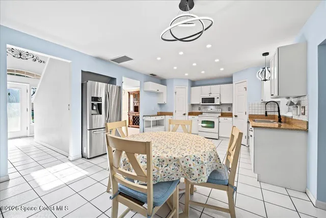 a kitchen with white cabinets a sink and white appliances
