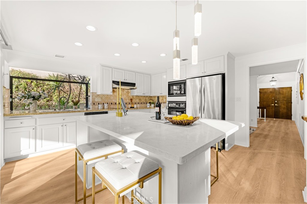 19 Alameda Irvine, CA 92620 - Photo 10 of 59 a kitchen with stainless steel appliances wooden floor and refrigerator