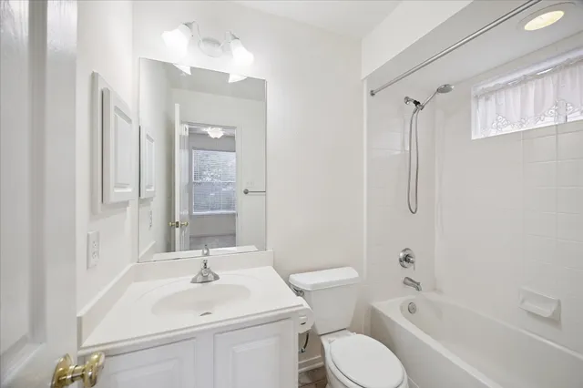 an empty room with a chandelier fan and windows