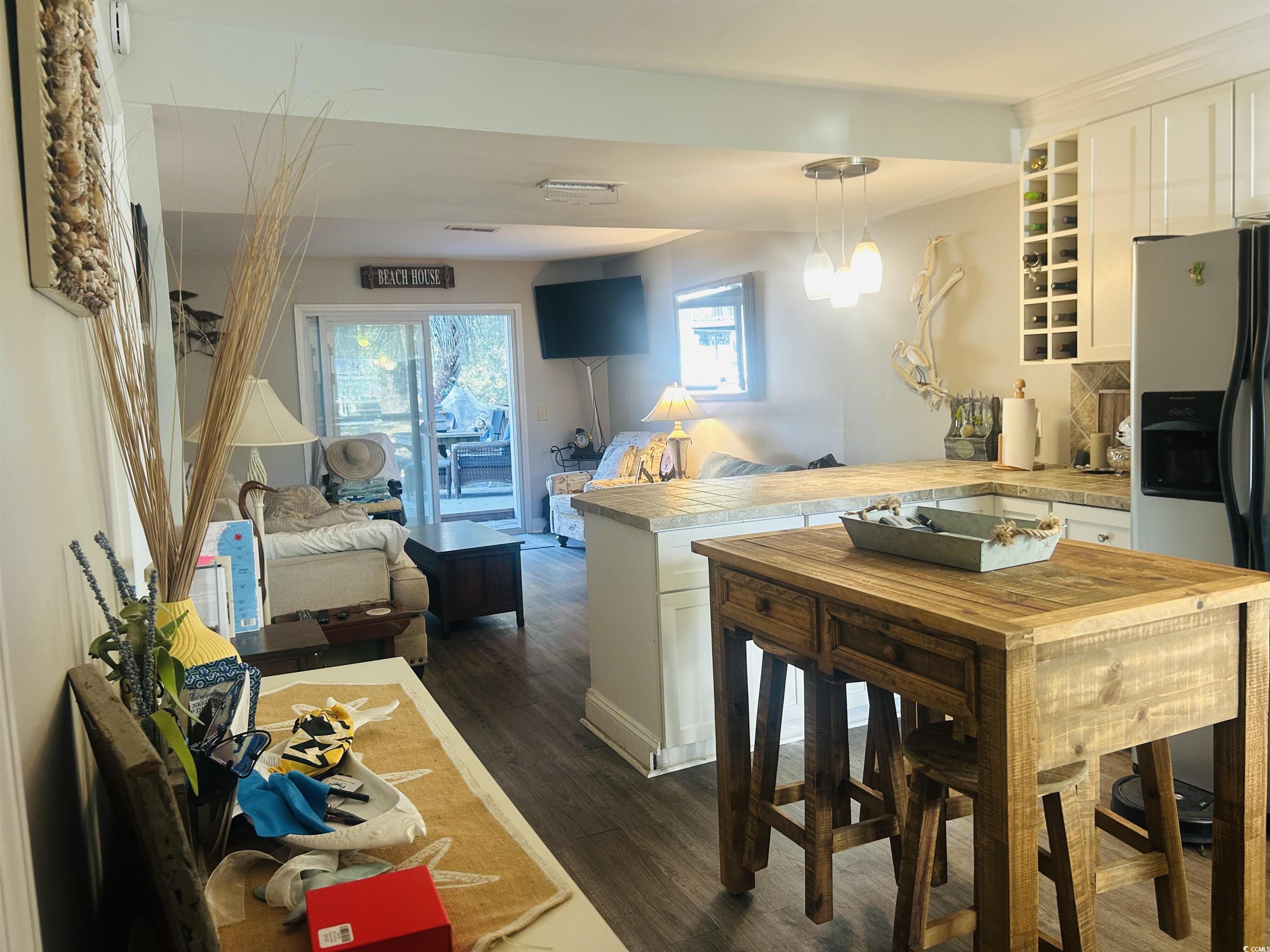 3866 Highway 17 Business, Unit C3 Murrells Inlet, SC 29576 - Photo 5 of 32 Kitchen with white cabinetry, stainless steel fridge with ice dispenser, dark hardwood / wood-style floors, kitchen peninsula, and pendant lighting
