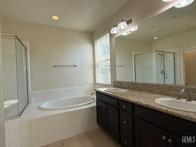 a bathroom with a granite countertop sink a toilet a mirror a bathtub and shower