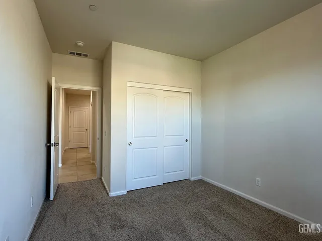 an empty room that has a glass door and closet