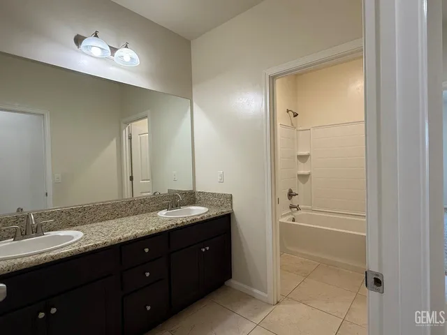 a bathroom with a granite countertop sink shower and a mirror