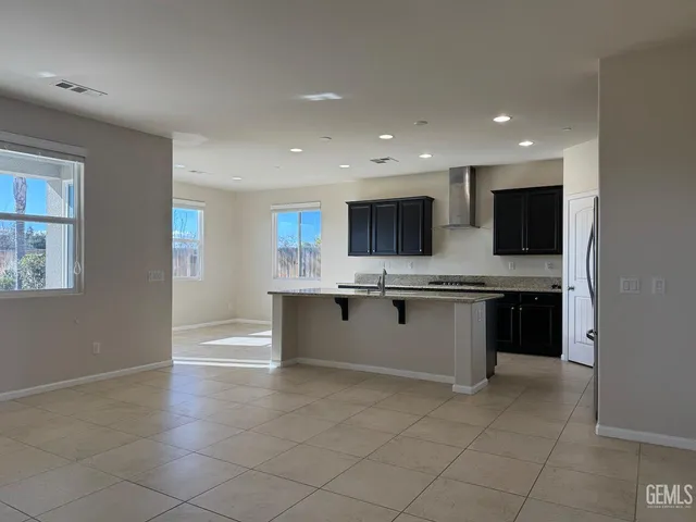 a large kitchen with a large counter top space a sink stainless steel appliances and cabinets