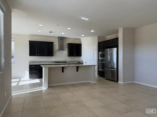 a kitchen with stainless steel appliances a refrigerator and a stove top oven