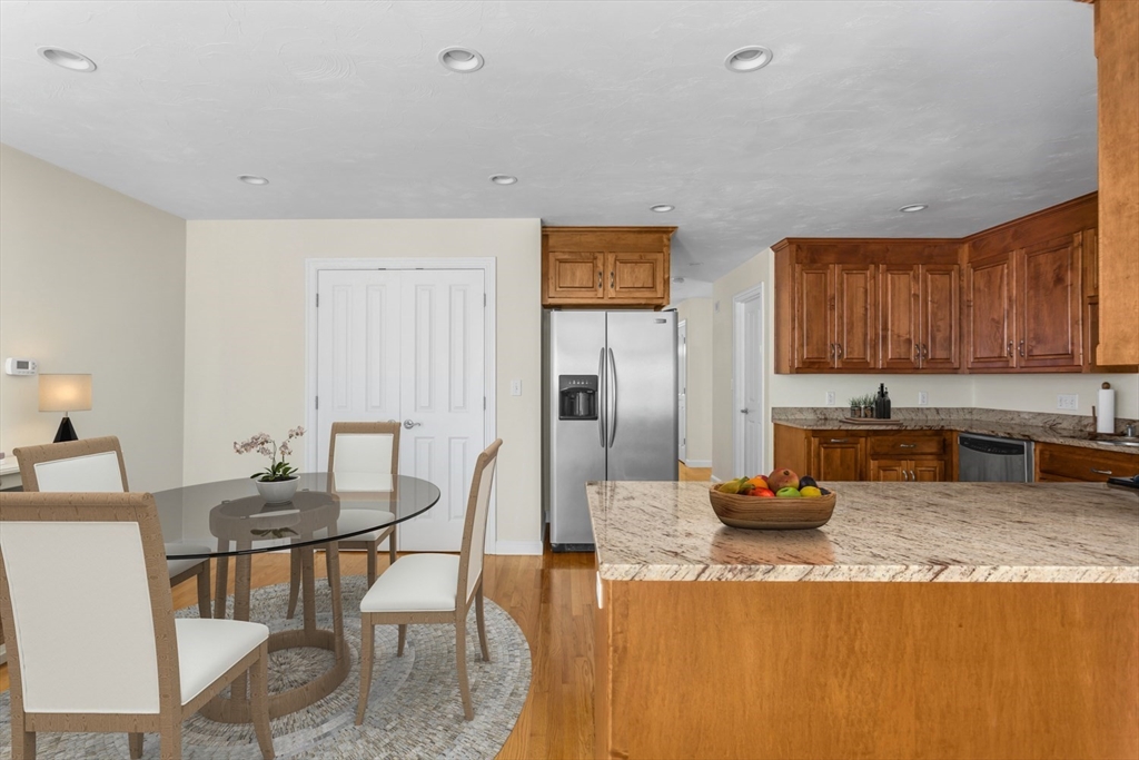 49 Beaver Street, Unit 49 Franklin, MA 02038 - Photo 2 of 46 a kitchen with stainless steel appliances granite countertop a stove top oven a dining table and chairs