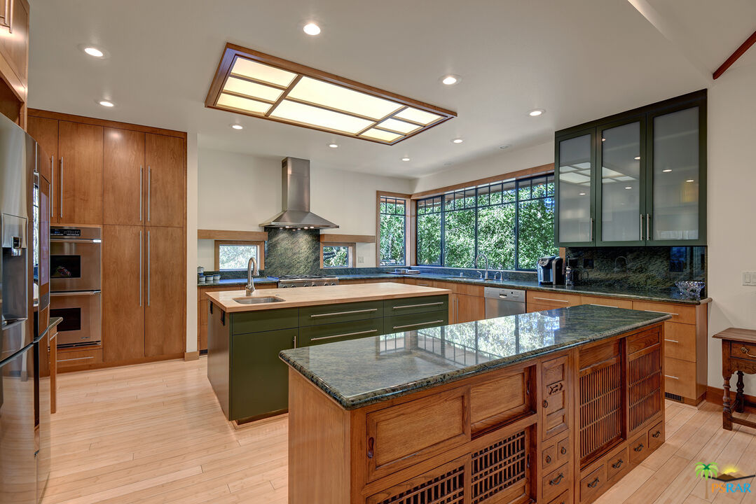 25445 Fern Valley Road Idyllwild, CA 92549 - Photo 23 of 52 a large kitchen with kitchen island a large counter top space a sink stainless steel appliances and cabinets